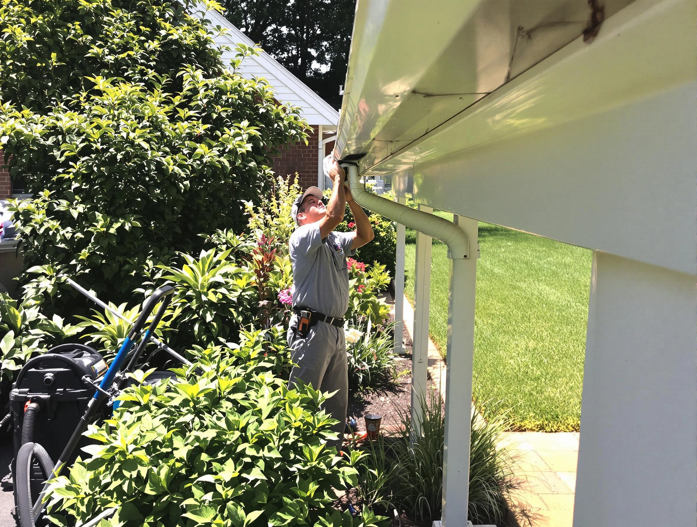 Technician flushing a blockage from a downspout in Brook Park, OH